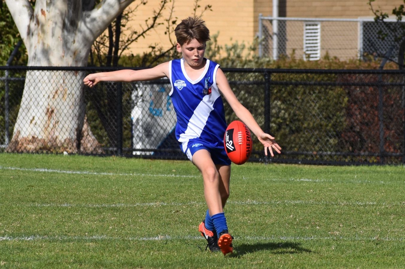 Junior AFL player kicking
